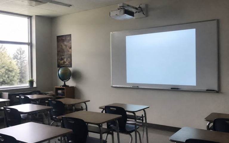 Beamer im Klassenzimmer über den Tischen